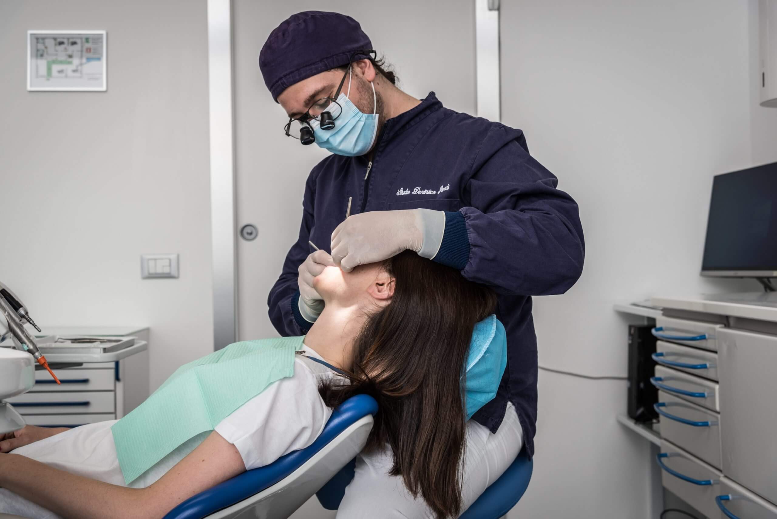 Dentista che sta intervenendo su un paziente